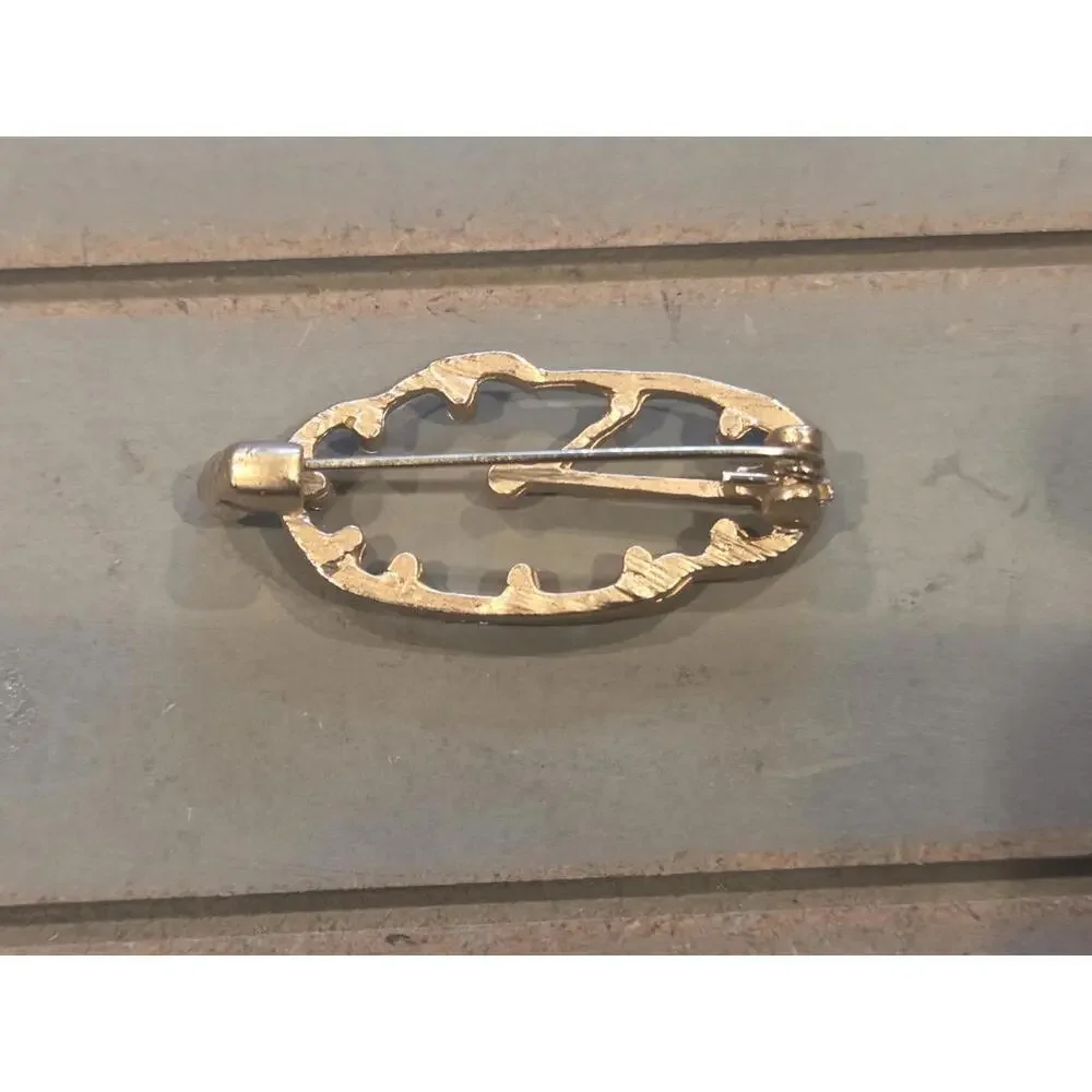 Golden with rhinestones melted clock brooch